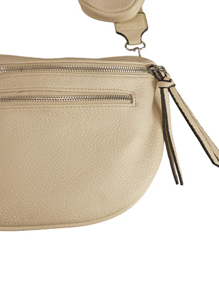 OFF#DLY Crossbody MID creme, Nahaufnahme einer creme-beigen Gürteltasche aus genarbtem Leder mit zwei silbernen Reißverschlussfächern, Lederzuglasche mit Fransen und abnehmbarem Riemen mit Metallschwenkverschluss.