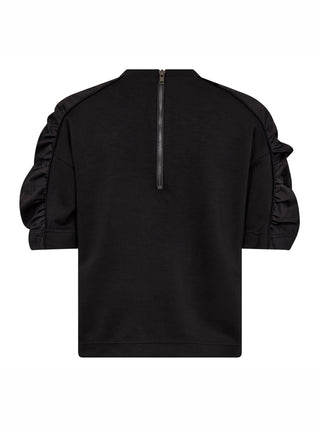 Das Co couture Lance Gathering Tee black zeigt eine gerade geschnittene Rückansicht mit Crewneck und mittigem Rückenreißverschluss. Puffed Ärmel mit Raffung an den Schultern verleihen dem Shirt eine feminine Silhouette.