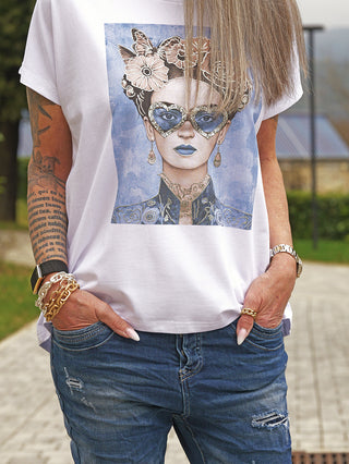 Das OFF#DLY Tee F.Karlo zeigt eine stilisierte Frau mit herzförmiger Sonnenbrille und blauen Lippen auf einem weißen, locker sitzenden T-Shirt, getragen von einer Person mit Jeans.