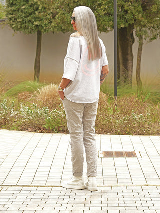 Person trägt OFF#DLY Joggjeans Genua grey mit leicht schmal zulaufendem Bein und Crinkle-Optik. Die Hose hat verstellbare Riemen am Bund und seitliche Taschen, kombiniert mit weißen High-Top-Sneakern.