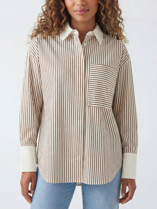 Person trägt Co Couture Avara Stripe Tee bone, eine langärmelige Streifenbluse mit kontrastierendem weißem Kragen und Manschetten, Brusttasche mit horizontalen Streifen, kombiniert mit hellblauer Jeans.