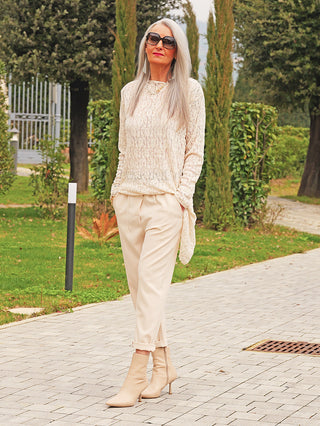 Eine schlanke Frau trägt das OFF#DLY Longshirt Spitze Tina beige, ein elegantes, langes Shirt aus strukturierter Spitze mit fließendem Schnitt, ideal für stilvolle Auftritte.