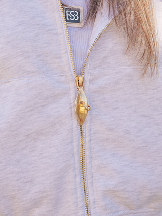OFF#DLY Sweatjacke KISS lightgrey, Nahaufnahme des goldenen Mundform-Reißverschlusses mit „FS3“-Etikett im Kragen, dezent getragen, betont sportlich-moderne und verspielte Eleganz.