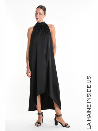 La Haine Dress 5285 black: Model trägt ein ärmelloses, hochgeschlossenes schwarzes Kleid mit asymmetrischem Saum und Lurex-Nadelstreifen, kombiniert mit schwarzen Block-Absatz-Sandalen und LA HAINE INSIDE US-Text rechts.