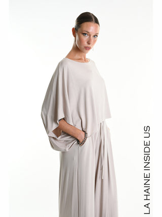 Modell trägt das La Haine Tee 5269 beige: ein fließendes, asymmetrisches Crop-Shirt aus weichem Bamboo-Jersey mit weiten Kimono-Ärmeln, das eine avantgardistische Silhouette bietet.