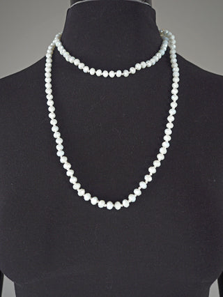 Schwarzer Display-Büste mit einer Glasperlenkette oval 7 mm weiß, doppelt getragen: Eine kurze Choker-Strang und ein längerer. Kette aus weißen Glasperlen, 58 cm lang.