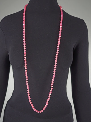 Glasperlenkette oval 7 mm pink auf schwarzer Schaufensterpuppe, bestehend aus einem langen, facettierten Strang kleiner rosa Perlen, der elegant über den schwarzen Stoff des Torsos fällt.