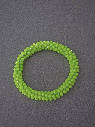 OFF#DLY Perlarmband green aus kleinen, facettierten, limefarbenen Glasperlen, kunstvoll zu einem Rohr gewebt, präsentiert als stilvolles Armband auf dunklem Hintergrund.