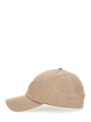 GUESS Basebal Cap TUP in Seitenansicht, beige, mit verstellbarer Größe und sichtbarem Logo, aus 100% Polyester, vor weißem Hintergrund.