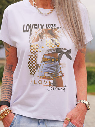 OFF#DLY Tee Short braun/blau mit auffälligem Frontprint, goldenen Akzenten und Statement-Design, getragen von einer Person mit Accessoires, darunter Kette und Armbanduhr.