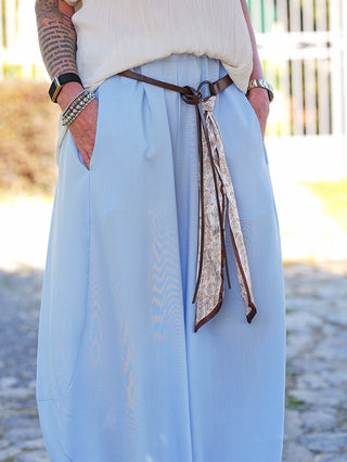 OFF#DLY Pant Andrea blue: Locker fallende Wide-Leg Hose mit elastischem Bund und seitlichen Taschen, ergänzt durch einen geknoteten Ledergürtel mit Paisley-Schal, getragen mit einem strukturierten, eingesteckten Top.