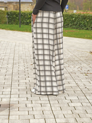OFF#DLY Hose Gesa beige/braun zeigt eine fließende, weite Silhouette mit Gummibund, die bis zum Knöchel reicht, ideal für entspannte Eleganz und maximalen Komfort auf gepflastertem Gehweg.