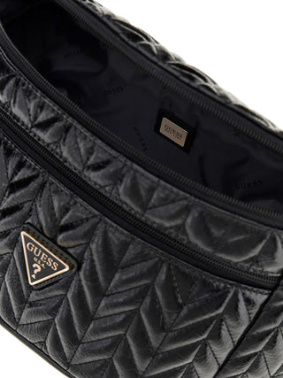 Nahaufnahme der GUESS Cheryl Belt Bag BLA mit chevronartigem Steppmuster, goldfarbenem Logo und Reißverschlüssen. Zeigt das gestempelte Innenfutter und die Metallplakette mit „GUESS EST. 1981“.