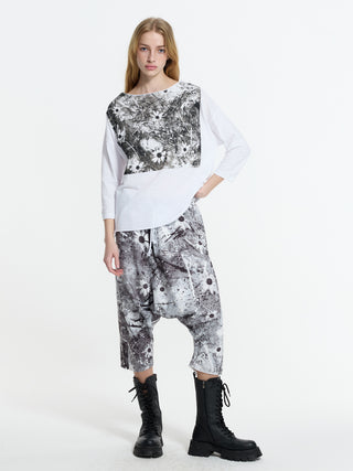 Modell trägt #VDR Tee 19083, ein locker geschnittenes Longsleeve mit schwarzem, künstlerischem Print, 3/4-Ärmeln, kombiniert mit passender Hose und schwarzen Schnürstiefeln.