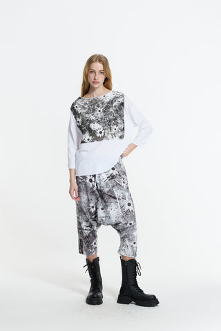 Modell trägt #VDR Hose 19048 black/white mit abstraktem Grafikprint und tiefem Schritt, kombiniert mit lockerem, passendem Oberteil und schwarzen, klobigen Schnürstiefeln.
