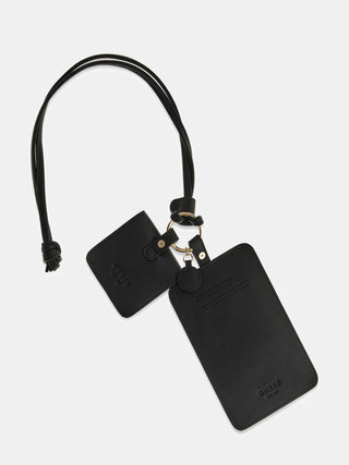 GUESS 4G Logo Handybag CMT: Schwarzes Kunstleder-Lanyard mit goldfarbenem O-Ring, zwei Pouches, GUESS-Logo-Prägung; ein rechteckiger Kartenhalter und eine quadratische Tasche.