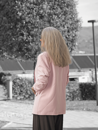 Person von hinten in einem OFF#DLY Blazer Dana rose mit klassischem Reverskragen, über dunkler Hose, stehend; betont elegante Passform und moderne Silhouette für vielseitige Stylingmöglichkeiten.