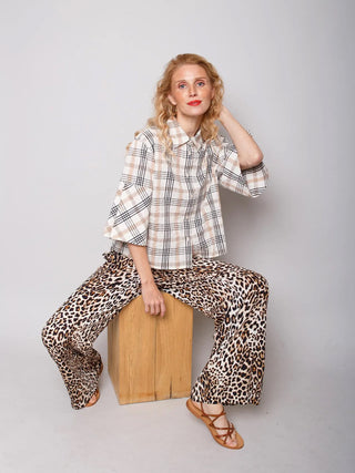 Emily Bluse 157960 cognac check: Eine lockere, dreiviertelärmelige Hemdbluse mit beigem und schwarzem Karo-Muster, präsentiert in einem lässigen, modernen Boxy-Schnitt, kombiniert mit weitem, entspanntem Design.