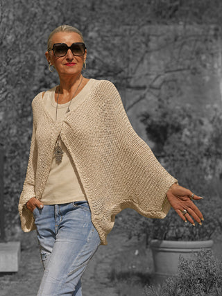 Ältere Frau trägt das OFF#DLY Netzoberteil Klara beige, ein locker gestricktes, offenes Netz-Cardigan über einem Tanktop, verleiht einen luftigen Boho-Stil, perfekt für sommerliche Layering-Looks.