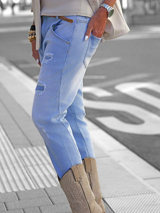 Person trägt OFF#DLY Denim Milano lightblue Jeans im modernen Used-Look, kombiniert mit braunen Wildleder-Cowboy-Stiefeln. Jeans wirken lässig mit umgeschlagenem Saum und betonen den entspannten Stil.