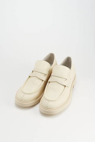 CPH 797 Vitello Butter: Slip-On Loafers mit klassischem Moc-Toe-Design, Penny-Strap-Detail und markanter Gummisohle. Elegante urbane Note durch weiches Lederfutter und leicht klobigen Absatz.