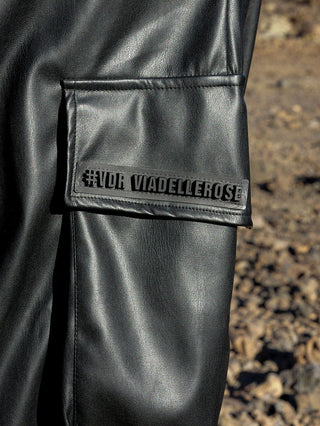 Nahaufnahme einer #VDR Wide Leg Pant aus schwarzem Kunstleder mit Cargo-Design, sichtbare Taschen und glatter Textur, passend für modische Outfits.