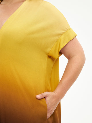 Mat Dress 8101.7078 in blassem Gelb, getragen von einer Person. Nahaufnahme zeigt eine Hand in der Tasche, betont das entspannte Design des Kleides aus 100% Viskose.