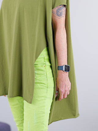 Person trägt ein SOHO-t T-Shirt Mogano khaki, kombiniert mit einer Uhr. Das T-Shirt hat einen seitlichen Schlitz und ist hinten länger geschnitten, mit einem Rundhalsausschnitt.