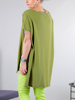 Person trägt SOHO-t T-Shirt Mogano khaki, lässige Tunika mit seitlichem Schlitz und längerem Rücken. Die Nahaufnahme zeigt Muster und Design des Shirts.