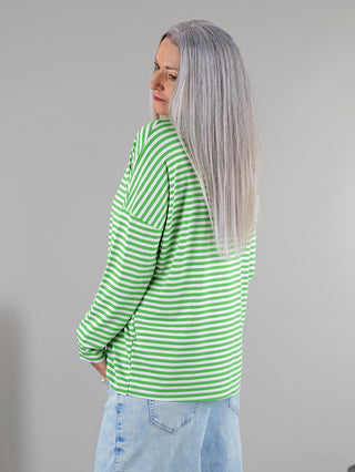 Frau mit grauen Haaren trägt das OFF#DLY Ringelshirt in Grün/Weiß. Das Langarmshirt hat einen Rundhalsausschnitt und lange Ärmel, perfekt für einen lässigen Look.