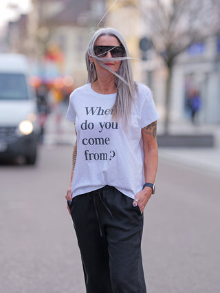 Eine Frau mit langen grauen Haaren trägt das ONE TEE Lisa white T-Shirt aus 100% Baumwolle und Sonnenbrille.