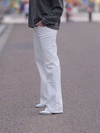 OFF#DLY Wide Leg Denim Romina, getragen von einer Person mit weißer Hose und grauem Pullover, silberne Schuhe, Fokus auf die weiten Beine der Hose.
