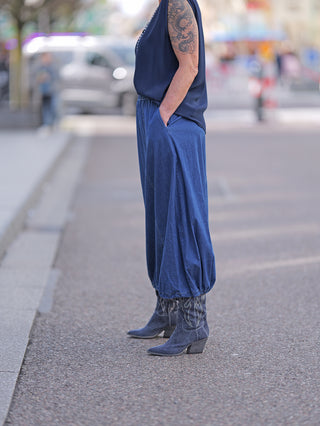 OFF#DLY Rock Julietta, getragen von einer Person mit blauen Hosen und Stiefeln, zeigt einen Denimrock mit Gummizug am Bund, ideal für lässige Straßenmode.
