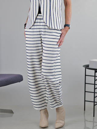 Eine Person trägt die SOHO-t Pant Dune beige blue, eine gestreifte Hose mit geradem, leicht weitem Schnitt und Gummizug am Bund.